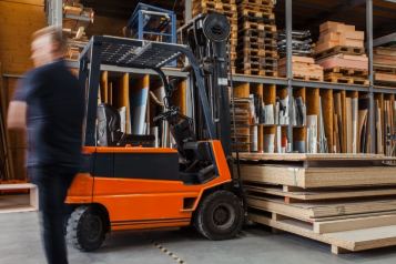 A forklift in a warehouse with lots of cardboard